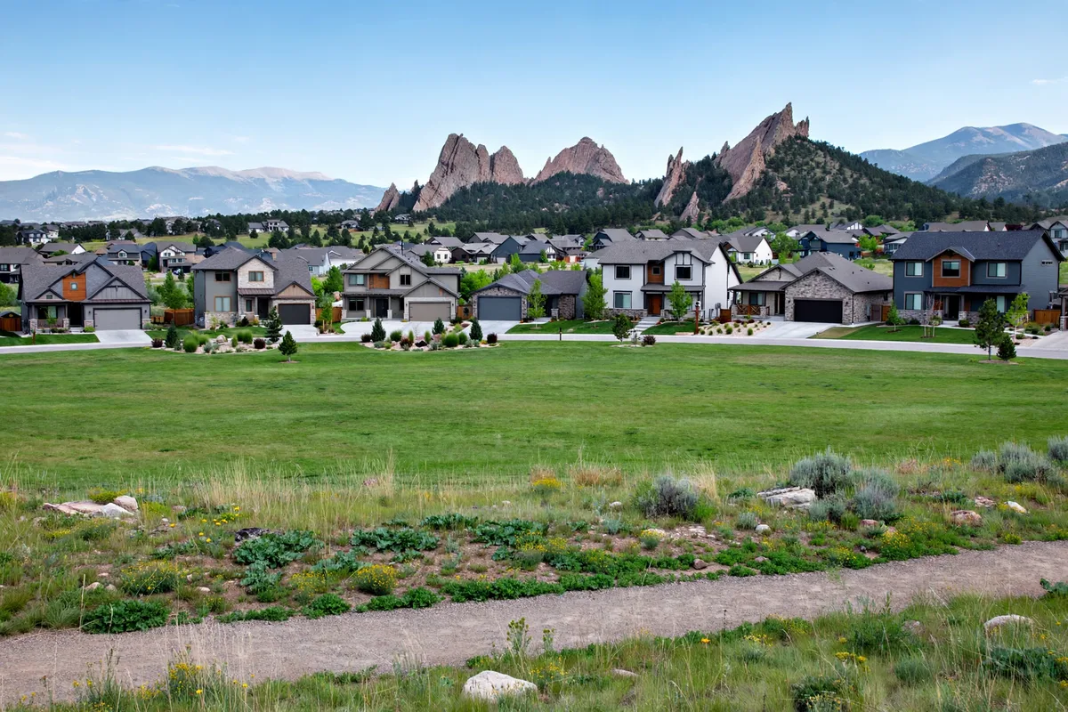 Broomfield homes with the Flatirons behind them and a trail crossing open space in the foreground
